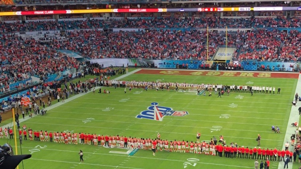 The Chiefs and 49ers stand at the 24-yard line to pay tribute to