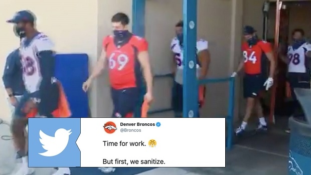 Denver Broncos players walk through sanitizing spray