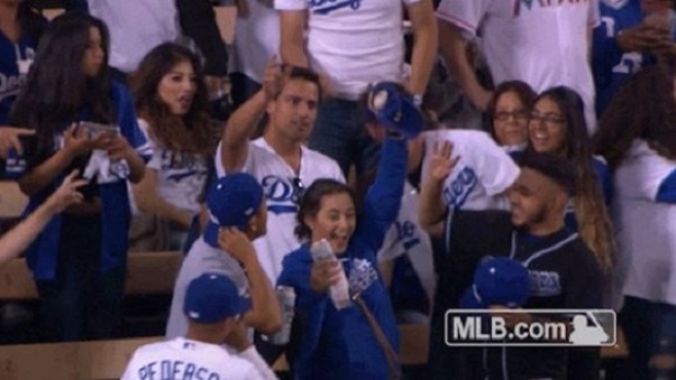 Dodgers fan catches home run with her hat while holding a beer in